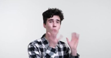 Beyaz arka planda kıvırcık saçlı beyaz bir adam. Eşsiz bir enerjiyle, kamerayı büyülüyor, izleyicileri etkileyici jestleri ve hareketli konuşmalarıyla kendine çekiyor..