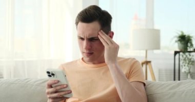 Oturma odasındaki kanepede oturan adam telefonunu karıştırmaya dalmış. Onun çatık kaşları ve düşünceli bakışları sorularla ve meraklarla dolu bir zihni ortaya çıkarıyor..