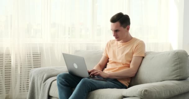 Hombre Caucásico Usando Portátil Cómodo Sofá Casa Con Una Expresión — Vídeos de Stock