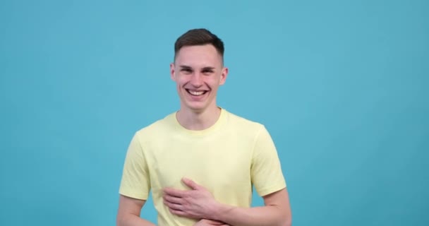 Кавказький Чоловік Вибухає Сміхом Захоплюючому Синьому Фоні Його Інфекційна Посмішка — стокове відео