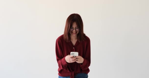 Kavkazská Dospívající Dívka Bílém Pozadí Jasným Úsměvem Jemným Smíchem Telefonem — Stock video