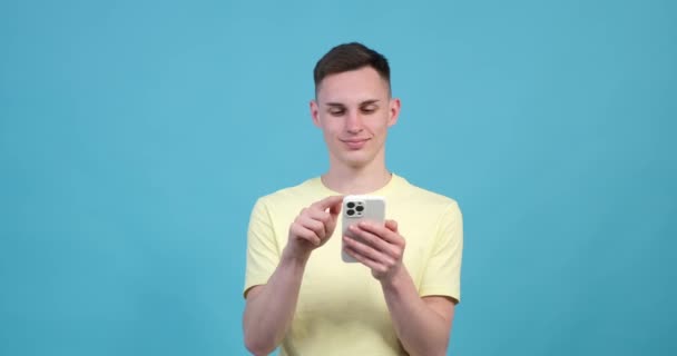 Fundo Azul Homem Caucasiano Segura Com Confiança Smartphone Sua Mão — Vídeo de Stock