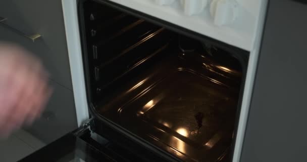 Mens Plaatst Zorgvuldig Een Met Muffins Gevulde Bakplaat Oven Met — Stockvideo