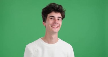 Canlı yeşil bir geçmişi olan beyaz bir adam, iyi bir jest yapıyor. Yüzünde sıcacık bir gülümsemeyle baş parmağını ve işaret parmağını uzatarak bir çember oluşturuyor..