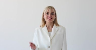 Temiz beyaz bir arka planda güzel bir kadın, zarif bir el hareketiyle havadar bir öpücük gönderiyor. Çekici gülüşü ve şakacı tavırları sevgi ve sıcaklık saçıyor..