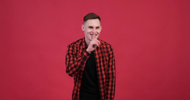 Vibrant Red Background Playful Caucasian Man Making Shh Gesture Holds — Stock Video