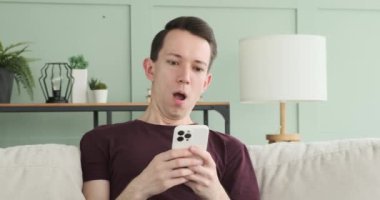 Kafkasyalı bir adamın oturma odasında telefonunu karıştırırken yakalanmasına şaşırdım. Yüz ifadesi, cihazında karşılaştığı içeriğe ve hayret duygusunu yansıtıyor..