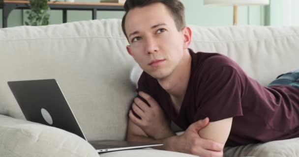 Düşünceli Bir Anda Genç Bir Adam Yanında Bir Dizüstü Bilgisayarla — Stok video