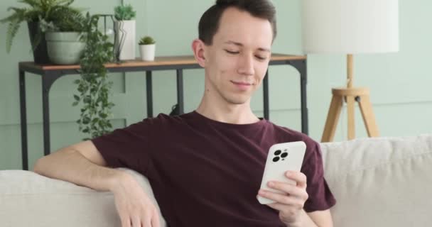 Beyaz Adam Oturma Odasındaki Kanepede Otururken Telefonunu Kullanırken Görülüyor Rahat — Stok video