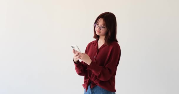Caucasian Teenage Girl White Backdrop Beaming Smile She Using Mobile — Stock Video