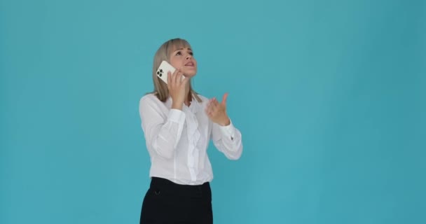 Soustředěná Běloška Vyobrazena Telefonním Rozhovoru Klidném Modrém Pozadí Její Soustředěný — Stock video