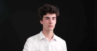 Siyah bir arka planda, genç beyaz bir adam şiddetle parmağını sallayarak inkar ediyor. Yüz ifadesi ve vücut dili açık bir anlaşmazlık mesajı iletiyor..