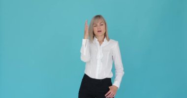 Sıkıntılı bir kadın, sakin mavi bir arka planda hayal kırıklığına uğrarken görülüyor. Sıkıntılı ifadesi ve el hareketi hayal kırıklığını ya da bıkkınlığı gösteriyor..