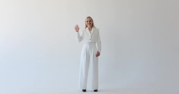 Φιλική Καυκάσια Γυναίκα Φαίνεται Ένα Καθαρό Λευκό Φόντο Κουνώντας Χέρι — Αρχείο Βίντεο