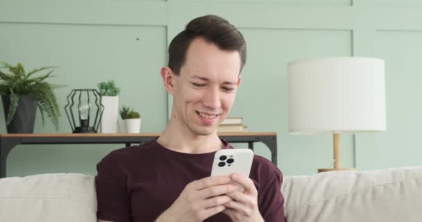 Neşeli Sahnede Genç Bir Adam Telefonuyla Mesajlaşırken Kahkaha Atarken Yakalandı — Stok video
