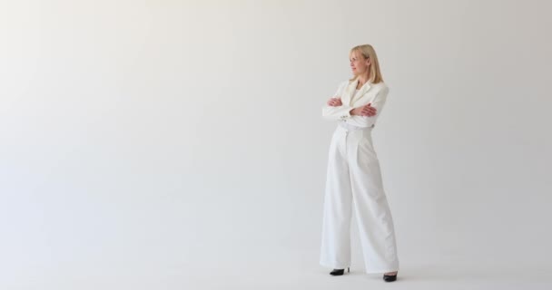 Une Femme Sophistiquée Vêtue Costume Blanc Immaculé Dresse Gracieusement Sur — Video