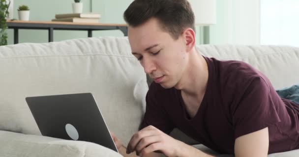 Чоловік Лежить Дивані Вітальні Своїм Ноутбуком Глибоко Думці Раптом Вигляд — стокове відео