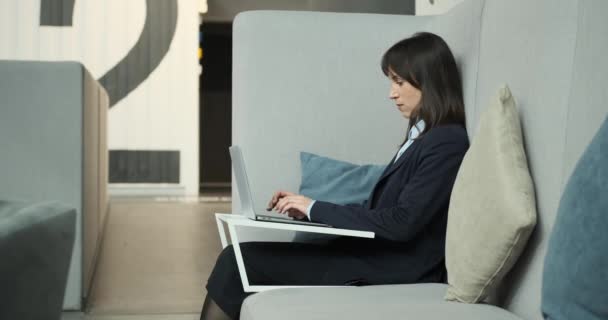 사무실 근로자는 편안하게 소파에 완전히 노트북에 자신의 작품에 편안하면서도 초점을 — 비디오