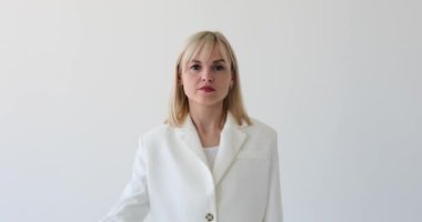 Tatmin olmamış bir kadın temiz beyaz bir zeminde baş parmağıyla onaylamadığını belirtirken görülüyor. Somurtkan ifadesi ve baş parmakları memnuniyetsizliğini gösteriyor..
