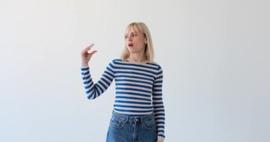 Canı sıkkın bir kadın beyaz bir arka planda hayal kırıklığını falan filanla ifade ederken görülüyor. Ellerinin kaldırdığı vesaire vesaire can sıkıntısı ya da sıkıntıya işaret ediyor..