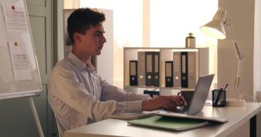 Yoğun ofis ortamında, işine dalmış odaklanmış bir işadamı masasında oturuyor. Parmakları dizüstü bilgisayarın klavyesinde hızla hareket ediyor ve elindeki görevlere olan bağlılığını yakalıyor..