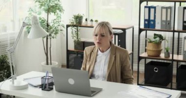 Enerjik bir kadın aktif olarak bir video araması ile iletişim kuruyor, bilgisayarından faydalanıyor. Canlı ifadelerle, coşkuyla sohbete dalıyor, dinamik kişiliğini gösteriyor..