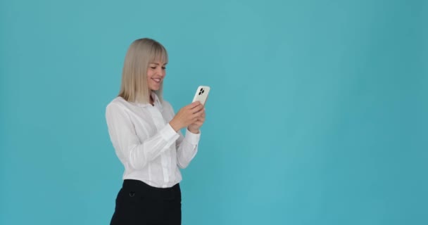 Радісна Жінка Захоплюється Щасливим Смс Повідомленням Своєму Телефоні Заспокійливо Блакитному — стокове відео