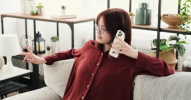 Kanepede rahat bir şekilde oturan neşeli bir genç kız canlı bir telefon görüşmesi yapar. Telefona hareketli bir şekilde konuşurken yüzü ışıl ışıl gülümsüyor. Mutluluk saçıyor..