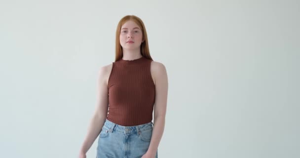Nespokojená Rudovlasá Dívka Ukazuje Prstem Dolů Bílém Pozadí Její Nespokojenost — Stock video