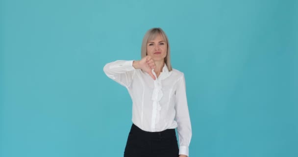 Unhappy Woman Expresses Dissatisfaction While Gesturing Thumbs Serene Blue Background — Stock Video