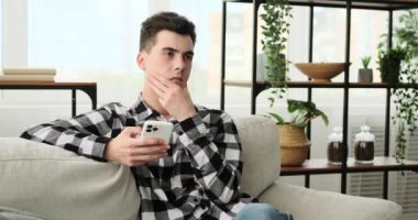 Telefonla oturan düşünceli bir adam, parlak bir fikir zihninde şekillenirken ışıldıyor. Atmosfer, yeniliğin doğuşunu yansıtan yaratıcı enerjiyle doludur..