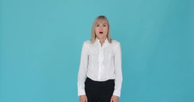 Huzursuz bir mavi arka planda olumsuz tepki gösteren tatminsiz bir kadın. Sert ifadesi ve hoşnutsuz tavrı olumsuz tepkisini ya da tatminsizliğini gösteriyor..