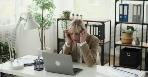 Mujer Sentada Oficina Sintiéndose Visiblemente Angustiada Mientras Lee Noticias Negativas — Vídeo de stock
