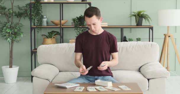 Mężczyzna Jest Widziany Jak Liczy Gotówkę Używając Kalkulatora Kanapie Salonie — Wideo stockowe