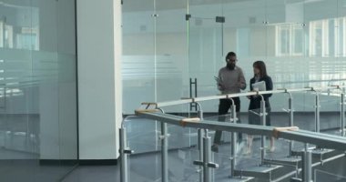 Ofis içinde, bir Hintli ve bir Kafkasyalı yönetici yürürken sohbet ediyorlar. Etkileşimleri, takım çalışmasının altında yatan yoldaşlığı ve fikir alışverişini somutlaştırır..