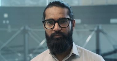 Bu samimi an, Hintli bir işadamını kameraya samimi bir gülümsemeyle bakarken yakalıyor. Onun yaklaşımsal tavrı ve sıcak ifadesi pozitiflik yayıyor ve bir bağlantı yaratıyor..