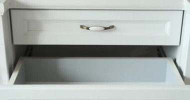 Bir kadın sevgiyle giysileri katlar ve onları şifoniyer çekmecesine koyar. Her dikkatli katlamayla, elbiseleri için bir sığınak yaratıyor, pratik bir karışımı somutlaştırıyor..