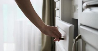 Bir kadın şifonyerin çekmecesini açar ve ustalıkla katlamaya başlar ve elbiselerini içeri yerleştirir. Düşünceli jestleri içeriği düzenlerken bir düzen ve işlevselliği simgeliyor..