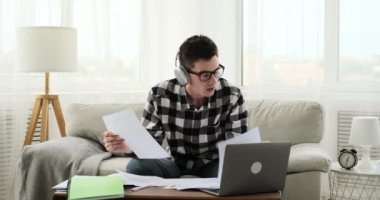 Bir video görüşmesini tamamladıktan sonra, hayal kırıklığına uğramış beyaz bir öğrenci belgeleri dağıtarak telaşlarını dile getiriyor. Bu an, duygularının yoğunluğunu yakalar..