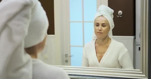 一个女人带着快乐的表情 在浴室里勤勤恳恳地刷牙 她灿烂的笑容和专注的日常活动反映了保持口腔卫生的重要性 — 图库视频影像