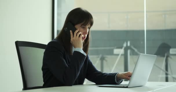 Női Menedzser Ahogy Ügyesen Vezeti Telefontárgyalásokat Miközben Szorgalmasan Dolgozik Laptopján — Stock videók