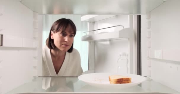 Hoşnutsuz Bir Kadın Buzdolabındaki Sandviçin Tazeliğini Kontrol Ediyor Bir Şişe — Stok video