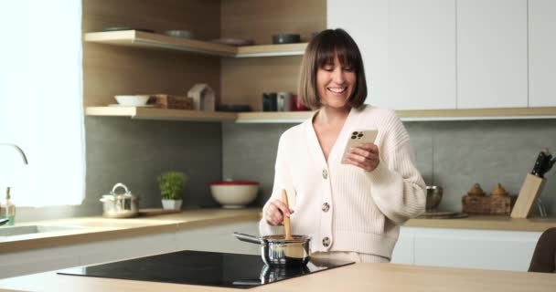 Una Donna Caucasica Multitasking Con Facilità Preparando Pasto Cucina Mentre — Video Stock