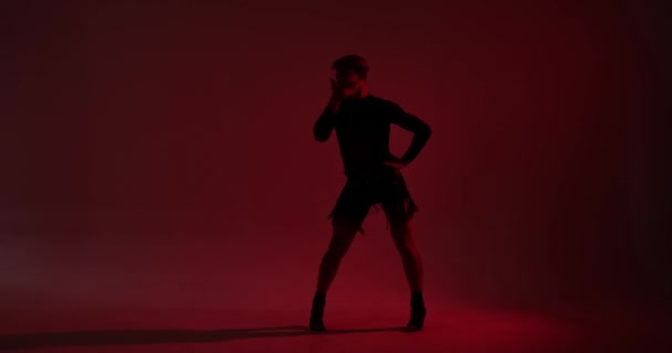 身着皮裙的白人后裔舞蹈演员引人注目的轮廓 在红色背景下表演着迷人的舞蹈 他们的舞蹈 以光与影的反差为亮点 — 图库视频影像