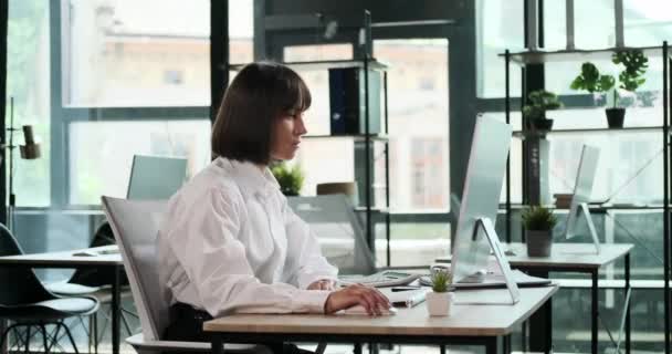 Masasında Oturan Kadın Bir Ofis Çalışanı Zarif Bir Şekilde Kulaklık — Stok video