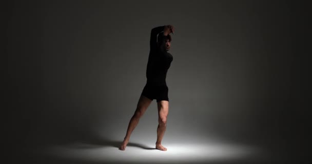 コーカサス遺産の才能あるダンサーは 対照照照明を受け入れる現代のダンスのスキルを示しています 彼らの表現的な動きは視覚的に魅了されるパフォーマンスを作成します — ストック動画