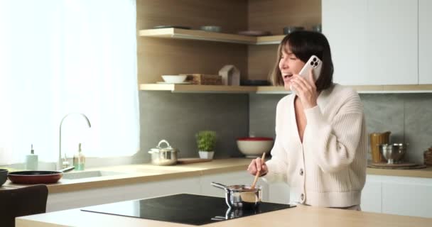 Una Donna Caucasica Multitasking Destreggia Una Conversazione Telefonica Mentre Cucina — Video Stock