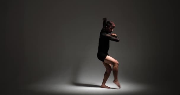 コーカサス降下のプロのダンサーは グレーの背景に対して精密に彼らの卓越したスキルを示しています 彼らのパフォーマンスは傑出し 視覚的に魅了されたダンス体験を作成します — ストック動画