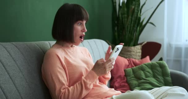 Przestraszona Kobieta Siedzi Kanapie Jej Palce Szybko Piszą Telefonie Wyraz — Wideo stockowe