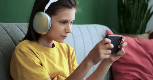Escolar Con Auriculares Disfruta Una Sesión Juego Teléfono Móvil Mientras — Vídeo de stock